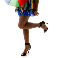Imagem das pernas de uma mulher com roupa carnavalesca e salto alto.