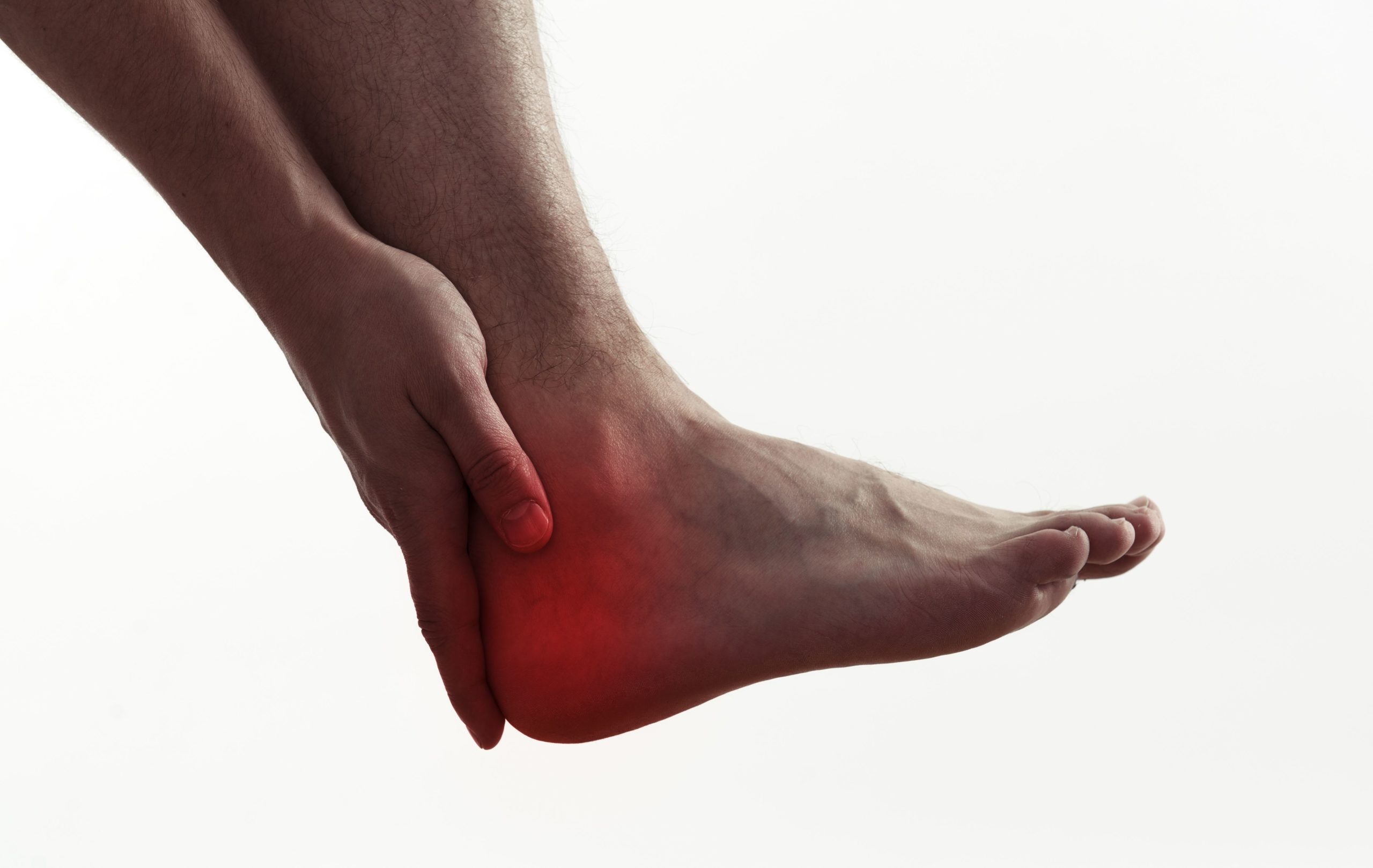 Imagem de uma pessoa sentindo dores no tendão na região do pé.